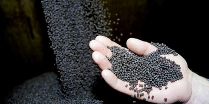 Extruded trout feed pellets in a hand